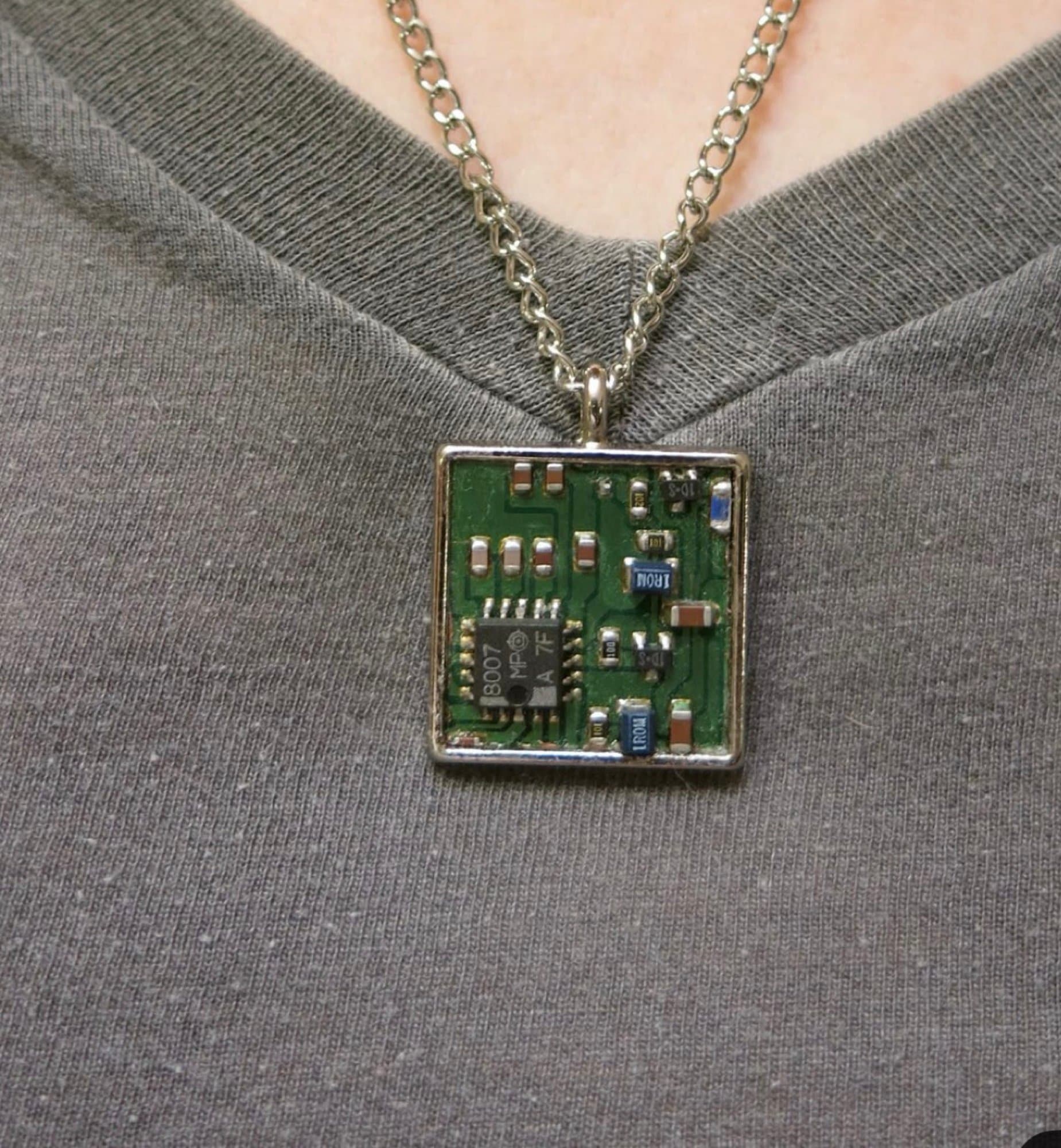 Square circuit board pendant necklace featuring electronic microchip components mounted in a polished silver bezel.